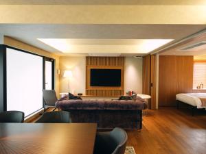 a hotel room with a bed and a television at The GOAT AWAJI in Kusumoto