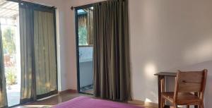 a bedroom with a bed and a desk and a window at Zen Space Nesat in Phumĭ Chroŭy Svay +8 photos