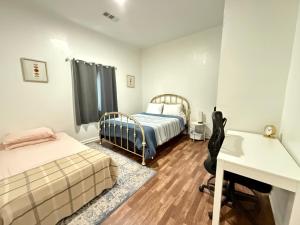 DinubaにあるGUEST RANCH HOUSE w POOL access near NATL PARKSのベッドルーム1室(ベッド2台、デスク、デスク付) +11枚の写真