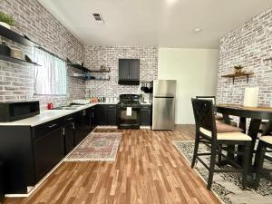 DinubaにあるGUEST RANCH HOUSE w POOL access near NATL PARKSのキッチン(黒いキャビネット、ステンレス製の冷蔵庫付)