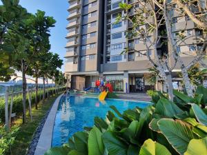 a swimming pool in front of a building at LoveStayBangi - Lake View, Sunway Gandaria, Bangi in Bandar Baru Bangi