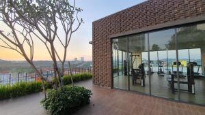 a brick building with glass windows and a tree at LoveStayBangi - Lake View, Sunway Gandaria, Bangi in Bandar Baru Bangi