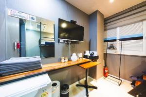 a room with a desk with a tv on the wall at MyeongDong New Stay Inn in Seoul +86 photos