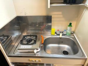 a kitchen with a sink and a stove at Docaホテル セルフチェックイン in Fukuoka +16 photos