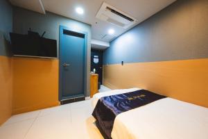 a bedroom with a bed and a blue door at MyeongDong New Stay Inn in Seoul