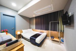 a hotel room with a bed and a television at MyeongDong New Stay Inn in Seoul