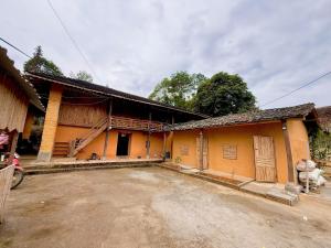 ein gelbes Gebäude mit einer unbefestigten Straße davor in der Unterkunft huy mán bungalow in Ha Giang