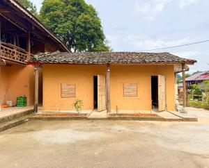 ein kleines gelbes Gebäude mit zwei offenen Türen in der Unterkunft huy mán bungalow in Ha Giang + 19 Fotos