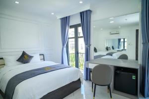 a bedroom with two beds and a desk with a mirror at 6668 Hotel - Chi nhánh 1 in Tây Ninh +94 photos