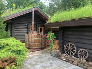 a log cabin with a wooden building with a grass roof at Russet & Rowanberry - Russet House in Paide