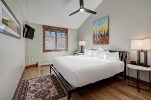 biała sypialnia z dużym białym łóżkiem i oknem w obiekcie Beautifully Updated Mountain Chic Condo condo w mieście Breckenridge