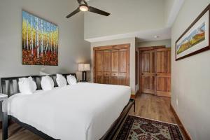 sypialnia z białym łóżkiem i wentylatorem sufitowym w obiekcie Beautifully Updated Mountain Chic Condo condo w mieście Breckenridge