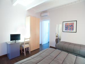 a bedroom with a bed and a desk and a television at B&B Il Falco in Castel del Monte