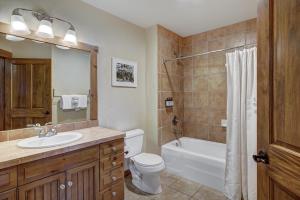 a bathroom with a sink and a toilet and a tub at Cozy Ski Chalet with Large Balcony condo in Breckenridge +19 photos