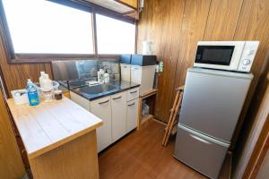 a small kitchen with a refrigerator and a microwave at Kawamura Apartment 202 in Harada