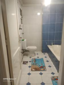 a bathroom with a toilet and a sink and a tub at AFB Hostel in Alexandria