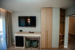 a room with a desk and a tv on the wall at Pensiunea Alpin in Durau