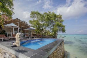 ein Haus mit einem Pool am Meer in der Unterkunft Wooden Beach Sunset Cottages in Nusa Lembongan