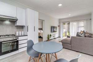 eine Küche und ein Wohnzimmer mit einem Tisch und einer Couch in der Unterkunft Country Charm 2Bed 2Bath Fourways Sandton in Chartwell