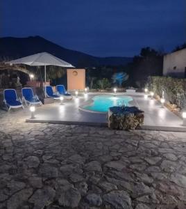 een zwembad met stoelen en een parasol bij Villa Nuccia Oasi di relax con piscina in Castellammare del Golfo