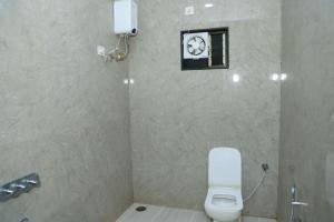 a bathroom with a white toilet and a sink at Shri Balaji Resort in Ellora