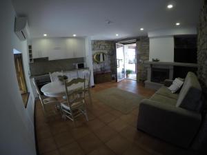 a kitchen and living room with a table and a couch at Puial de l Douro in Miranda do Douro