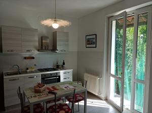 a kitchen with a table with chairs and a window at Cà di Boschetti Old Farm f in La Spezia