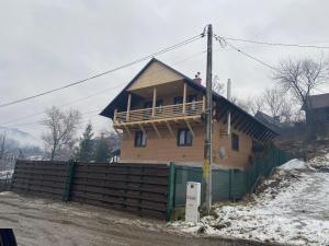 a wooden house with a balcony on top of a fence at SKH R - 1 Bedroom in Praid