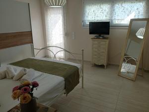 a bedroom with a bed and a tv and a mirror at Peramos View Luxury Maisonette in Nea Peramos