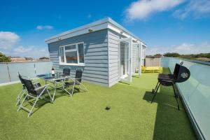 a tiny house on a roof with a table and chairs at Surfside Penthouse in Bournemouth