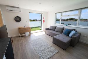 a living room with a couch and a television at Surfside Penthouse in Bournemouth