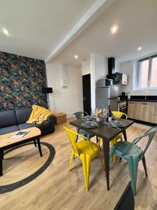 een woonkamer met een tafel en gele stoelen bij Au bord de Mers in Mers-les-Bains