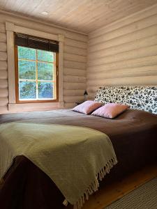 Un dormitorio con una cama grande en una habitación con ventana. en Villa Saimaa, en Vuoriniemi