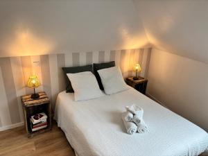 een slaapkamer met een bed met twee gevulde olifanten erop bij Au bord de Mers in Mers-les-Bains