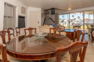 a living room with a wooden table and chairs at Dolphin Place in Velddrif