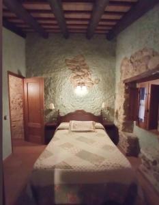 Llinars del VallèsMasia Can Felip B&B的一间卧室，石墙内有一张床