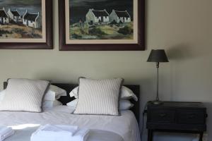 ウィルダネスにあるTURACO HOUSEのベッドが2つあり、壁に絵が飾られた寝室