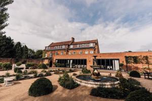 un gran edificio de ladrillo con una fuente frente a él en Bowburn Hall Hotel, en Durham