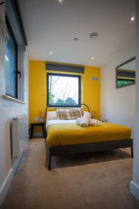 a bedroom with a bed with yellow walls and a window at Beachside Bliss in Bournemouth