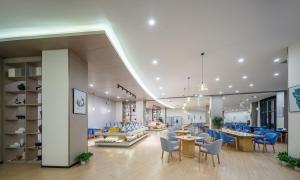 a lobby of a hospital with blue chairs and tables at Guanghan Exhibition International Hotel in Guanghan
