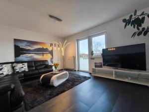 a living room with a couch and a flat screen tv at Ferienhaus Goldgrube - 5 Zimmer - 140qm am Fluss in Katzweiler