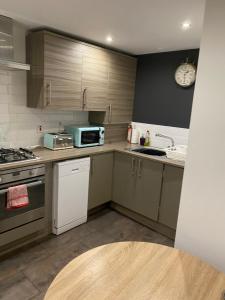 a kitchen with a stove and a microwave at Mossie Apartment in Ayr