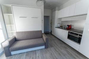 ein Wohnzimmer mit einem Sofa in der Küche in der Unterkunft Studio cosy avec jardin privatif proche transport in Vénissieux