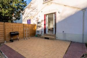 eine Terrasse mit einem Holzzaun neben einem Haus in der Unterkunft Studio cosy avec jardin privatif proche transport in Vénissieux