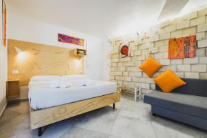 a bedroom with a bed and a couch at Le Cave di Fontane Bianche in Cassibile +37 photos
