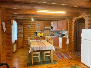 a kitchen and dining room with a table in a log cabin at Saimaa Raikala in Vuoriniemi +55 photos