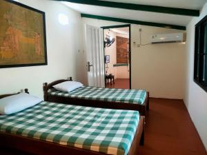 una habitación con dos camas y un espejo en Paviliun Omah Ndanu, en Yogyakarta