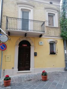 a building with a balcony and a door and flowers at B&B Da Nonna 'Nzia in SantʼEusanio del Sangro