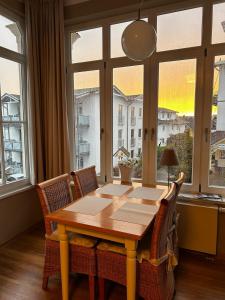a dining room table with chairs and a large window at Villa Heimkehr Apartment 6 in Göhren