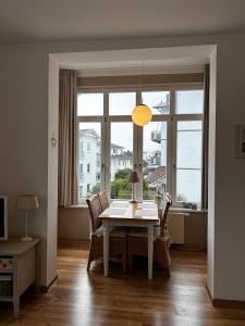 a dining room with a table and chairs and a window at Villa Heimkehr Apartment 6 in Göhren +7 photos